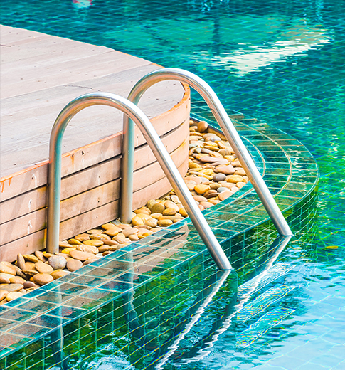 Well-kept backyard pool with stone-bordered wood deck serviced by H2Oasis in Minneola, FL