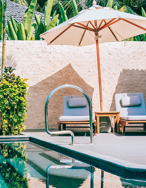 Poolside patio with loungers and umbrella beside a clean pool in Oviedo, FL